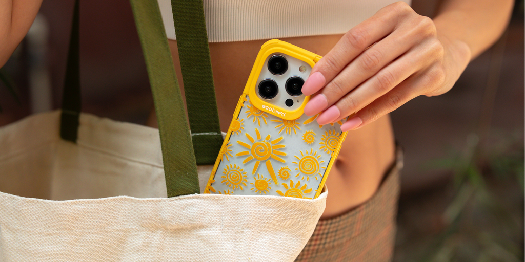 Summer Collection Blog - A Woman Puts An EcoBlvd Phone Case With Eternal Sunshine Design In Yellow Into Her Tote Bag