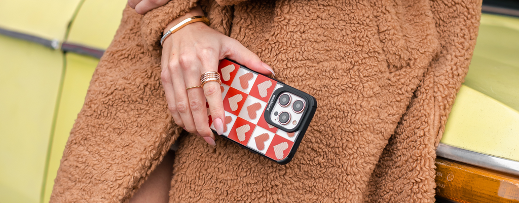EcoBlvd's Quilty Pleasures Phone Case on an iPhone held by a woman in a brown sherpa coat