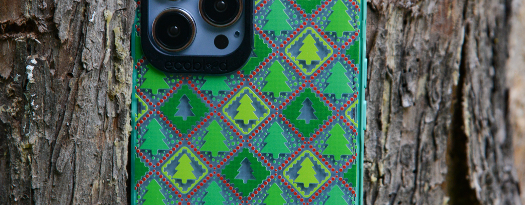 EcoBlvd - Green Laguna Eco-Friendly Phone Case With The Feeling Jolly Design For iPhone Placed Against A Tree.