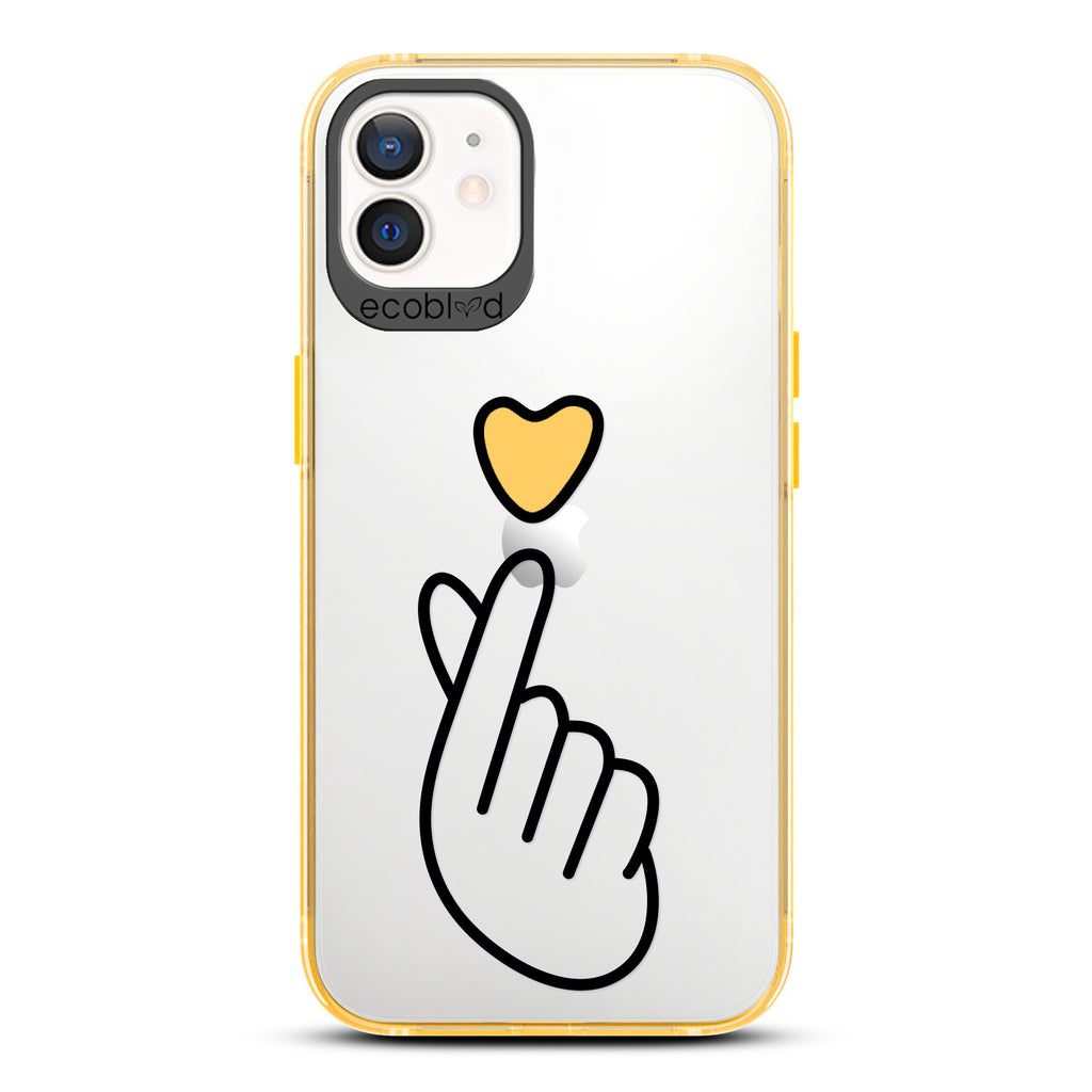 Love Collection - Yellow iPhone 12 / 12 Pro Case - Yellow Heart Above Hand With Index Finger & Thumb Crossed On Clear Back